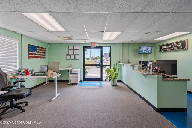a view of a livingroom with workspace and a window