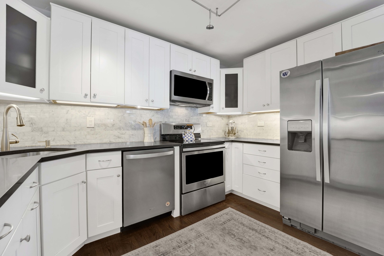 3150 North Sheridan Road, Unit 14A Chicago, IL 60657 - Photo 3 of 31 a kitchen with stainless steel appliances white cabinets and a granite counter top