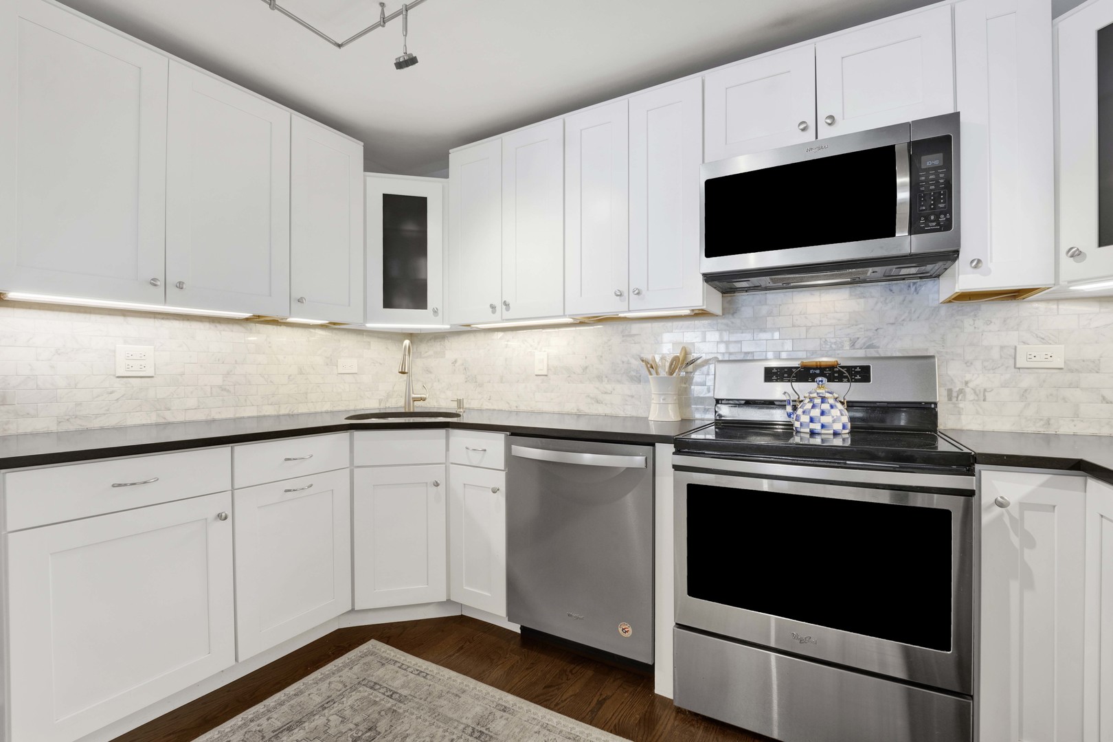 3150 North Sheridan Road, Unit 14A Chicago, IL 60657 - Photo 5 of 31 a kitchen with stainless steel appliances granite countertop grey cabinets a stove a sink and dishwasher