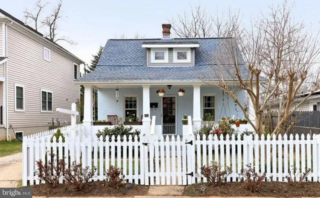 a front view of white house with a small yard