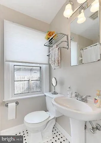 a bathroom with a sink a toilet and a mirror