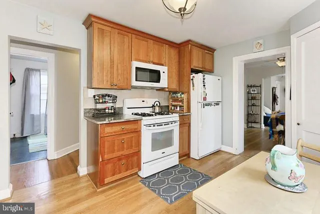 a kitchen with stainless steel appliances a refrigerator a stove a sink and white cabinets