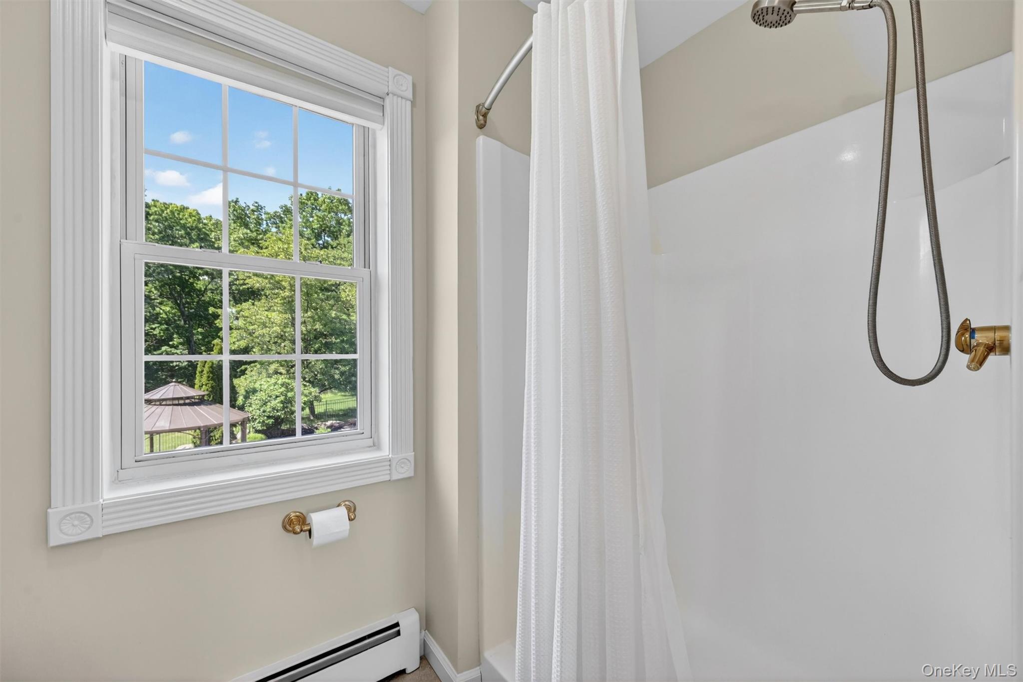 954 Ridgebury Road New Hampton, NY 10958 - Photo 32 of 45 A step-in shower and peaceful window view complete the second-floor ensuite, creating a bright and practical bath space for this private upstairs suite.