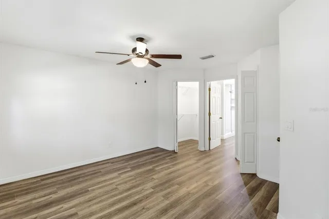 a view of room with hardwood floor and a ceiling fan