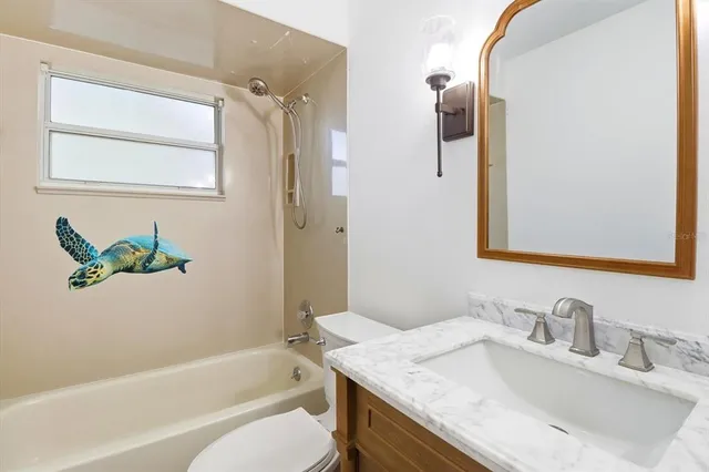 a bathroom with a granite countertop sink mirror and a bathtub