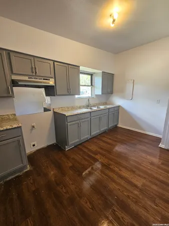 a room with a chair and white cabinets