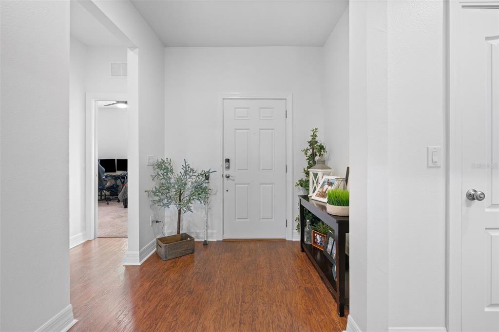 4730 111th Terrace East Parrish, FL 34219 - Photo 11 of 60 a hallway with painting on the wall and a potted plant