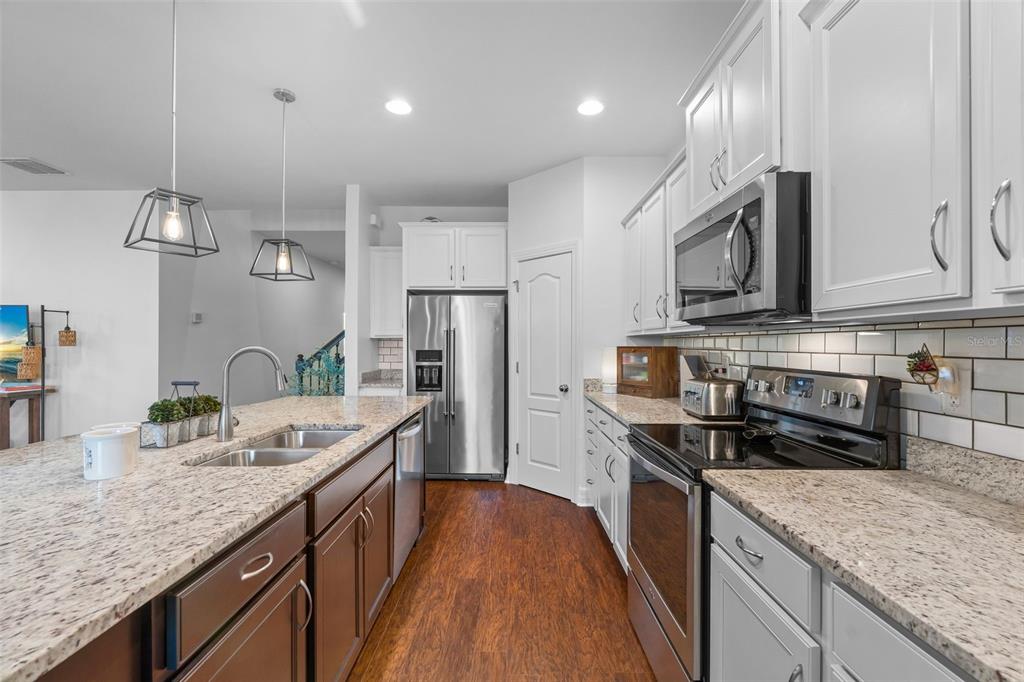 4730 111th Terrace East Parrish, FL 34219 - Photo 14 of 60 a kitchen with stainless steel appliances granite countertop a sink stove microwave and cabinets