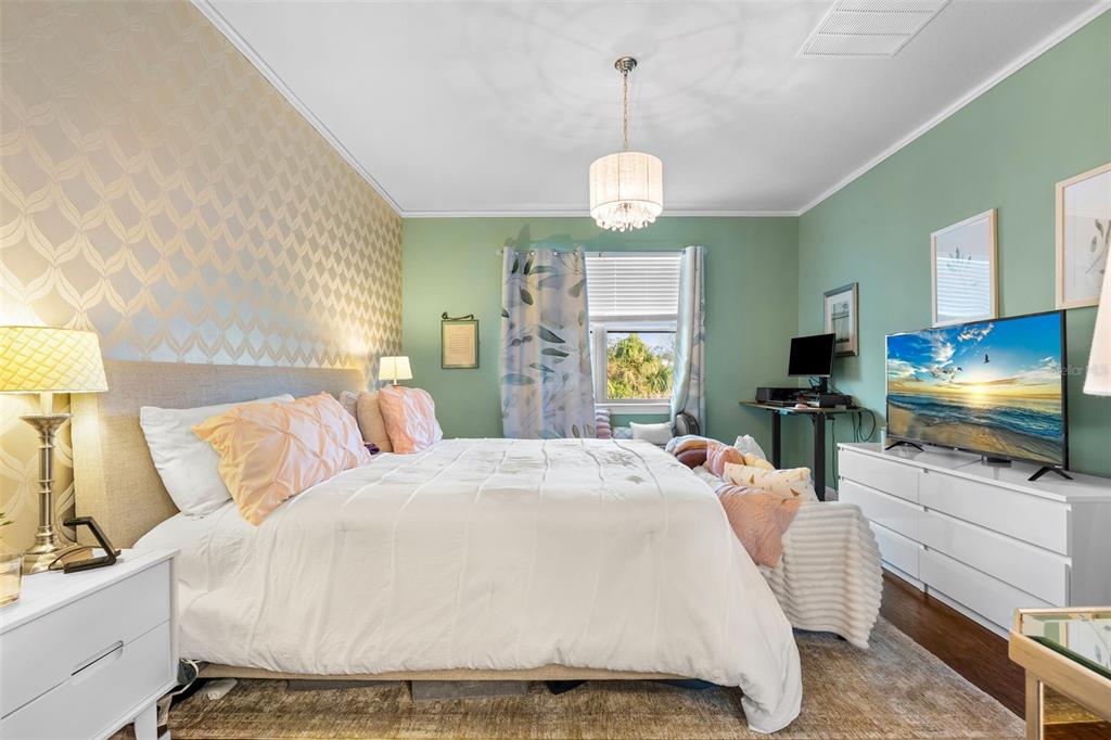 4730 111th Terrace East Parrish, FL 34219 - Photo 21 of 60 a bed room with a bed mirror and a flat tv screen on dresser