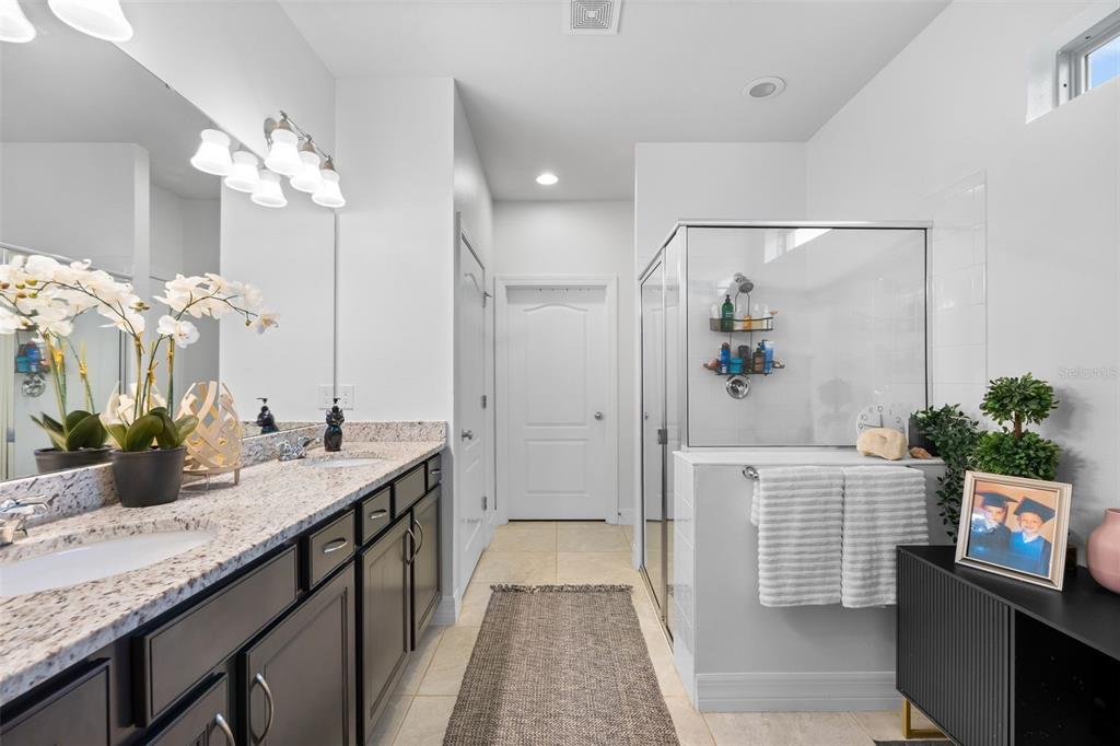 4730 111th Terrace East Parrish, FL 34219 - Photo 23 of 60 a spacious bathroom with a granite countertop sink a mirror and a shower