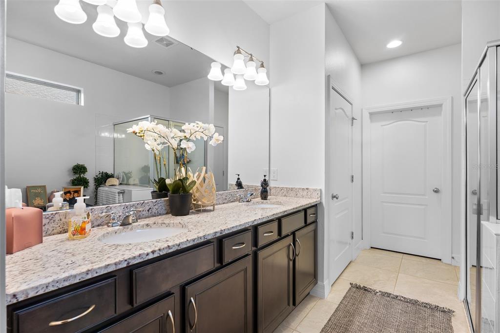 4730 111th Terrace East Parrish, FL 34219 - Photo 24 of 60 a bathroom with a granite countertop sink a large mirror and a shower
