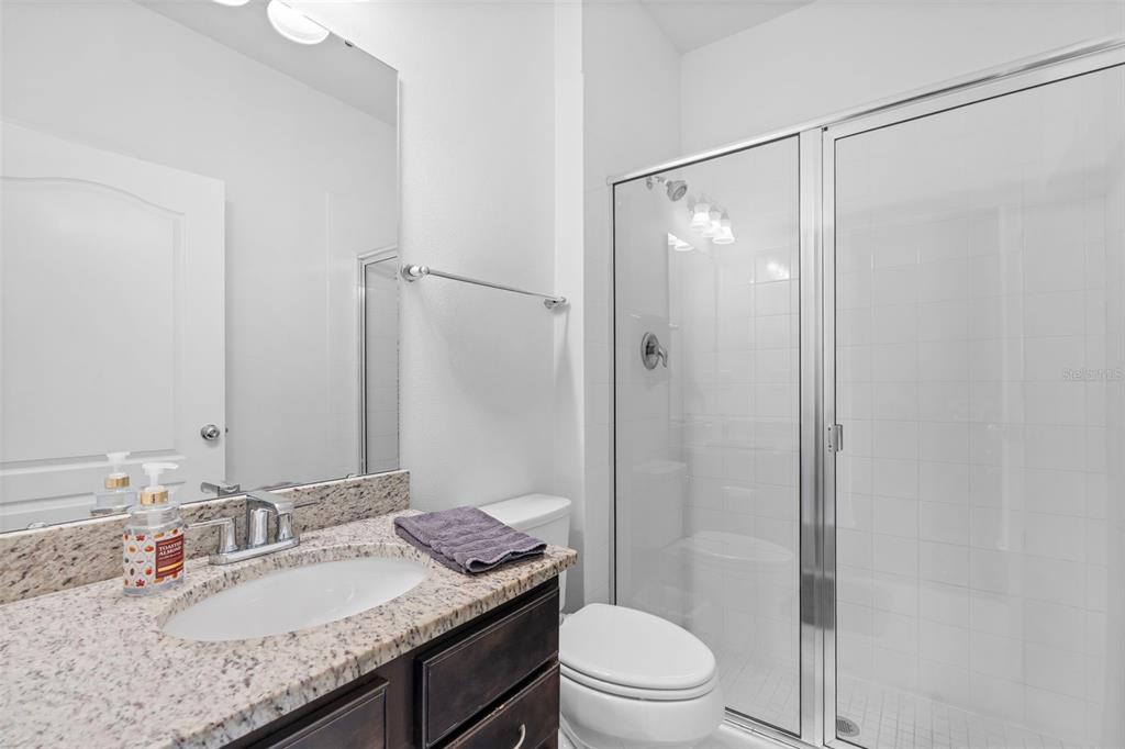 4730 111th Terrace East Parrish, FL 34219 - Photo 27 of 60 a bathroom with a granite countertop sink toilet and shower