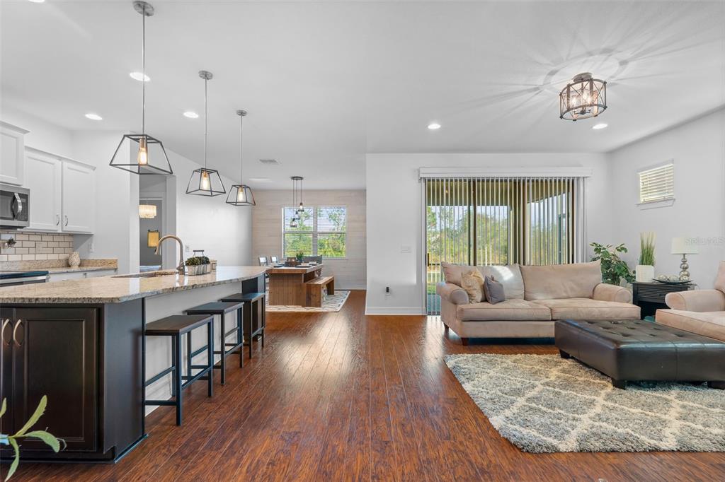 4730 111th Terrace East Parrish, FL 34219 - Photo 3 of 60 a living room with furniture kitchen view and a wooden floor