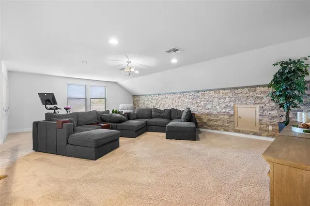 a living room with patio furniture and a garden