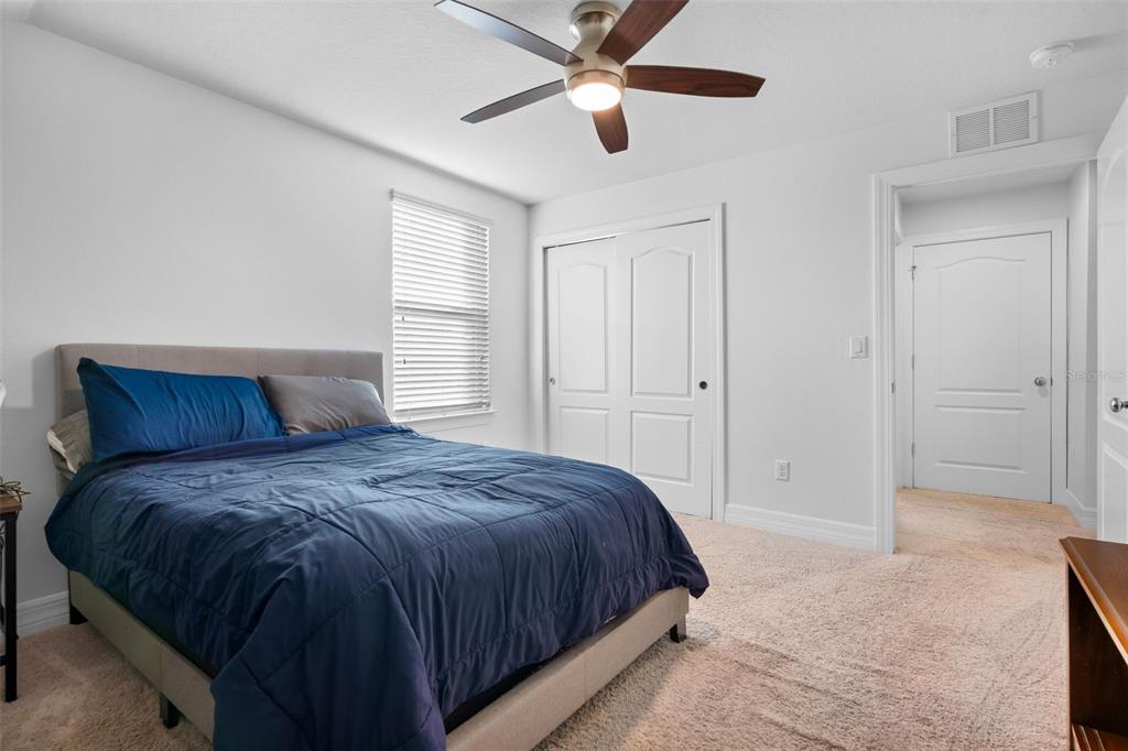 4730 111th Terrace East Parrish, FL 34219 - Photo 33 of 60 a spacious bedroom with a bed and a ceiling fan
