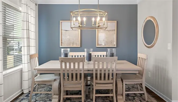 a view of a dining room with furniture a chandelier and wooden floor