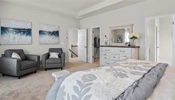 a spacious bedroom with a bed a couch and dresser