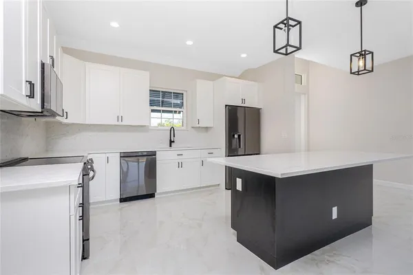 a kitchen with a refrigerator a sink and cabinets