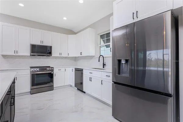 a kitchen with stainless steel appliances and refrigerator