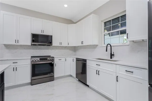 a kitchen with cabinets stainless steel appliances and a sink