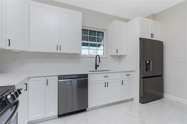 a kitchen with stainless steel appliances white cabinets and a refrigerator