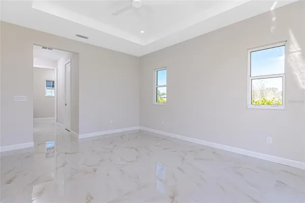 an empty room with windows and mirror