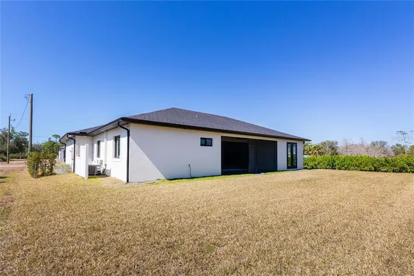 a yellow house with a big yard and large trees