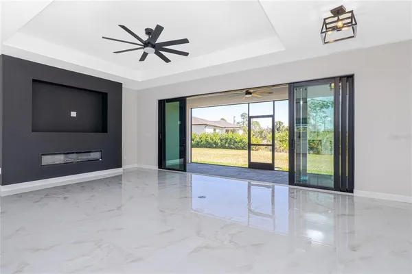a view of an empty room with a window and a ceiling fan