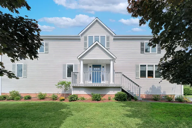 a front view of a house with a garden and plants