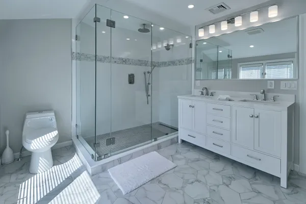 a bathroom with a toilet a sink and glass door