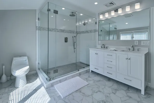 a bathroom with a toilet a sink and glass door
