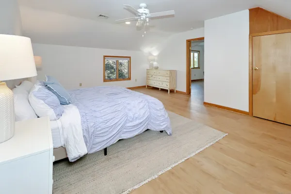 a spacious bedroom with a bed and a lamp