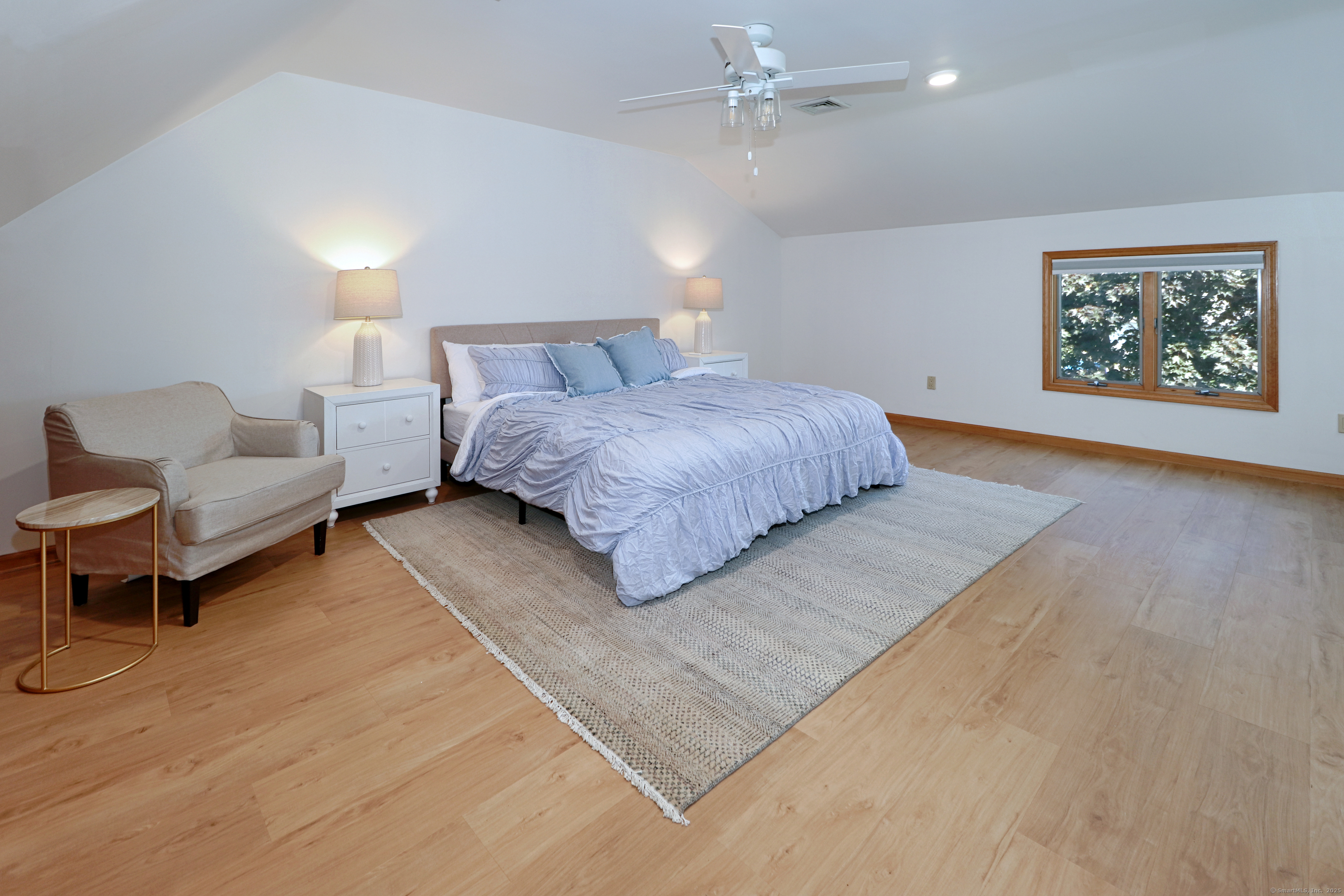 560 Fairfield Beach Road Fairfield, CT 06824 - Photo 24 of 38 a spacious bedroom with a bed a couch and painting on the wall