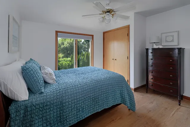 a bedroom with a bed a dresser and a window