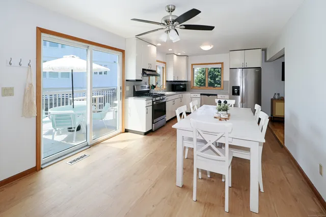 a kitchen with a table chairs refrigerator and microwave
