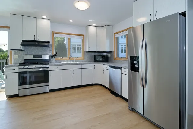 a kitchen with stainless steel appliances a refrigerator sink and cabinets