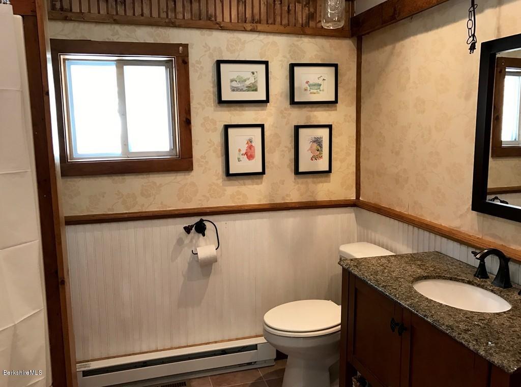 47 Thompson Road Colrain, MA 01340 - Photo 16 of 17 a bathroom with a granite countertop toilet sink and mirror