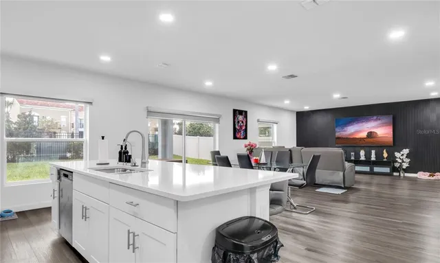 a kitchen with a sink stainless steel appliances and white cabinets