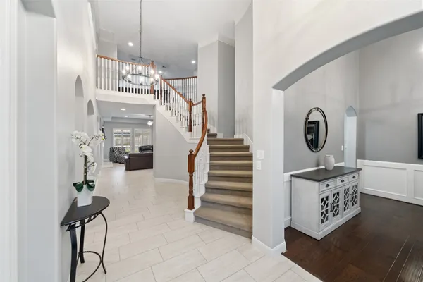 a kitchen with stainless steel appliances granite countertop a stove a sink a refrigerator white cabinets and chairs