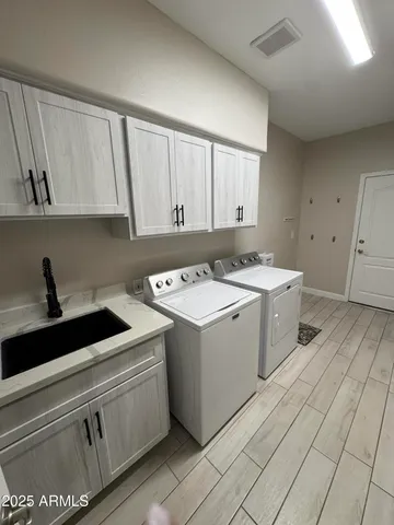 a utility room with cabinets washer and dryer