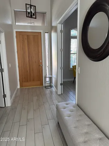 a view of a hallway with wooden floor and furniture