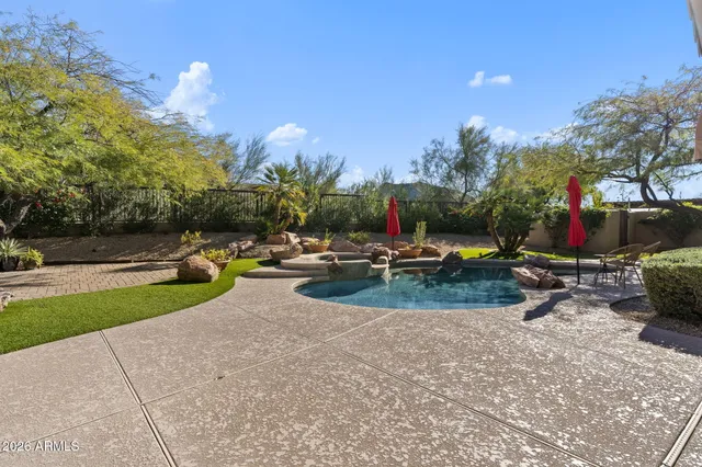 a view of a yard with plants and a barbeque