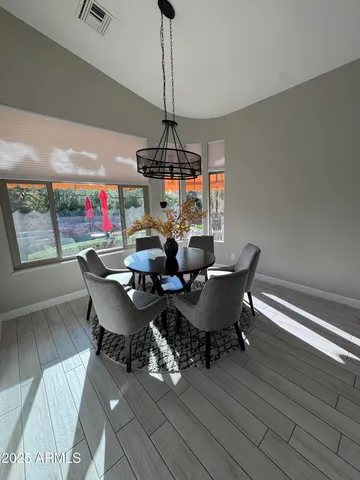 a dining room with furniture a chandelier and wooden floor
