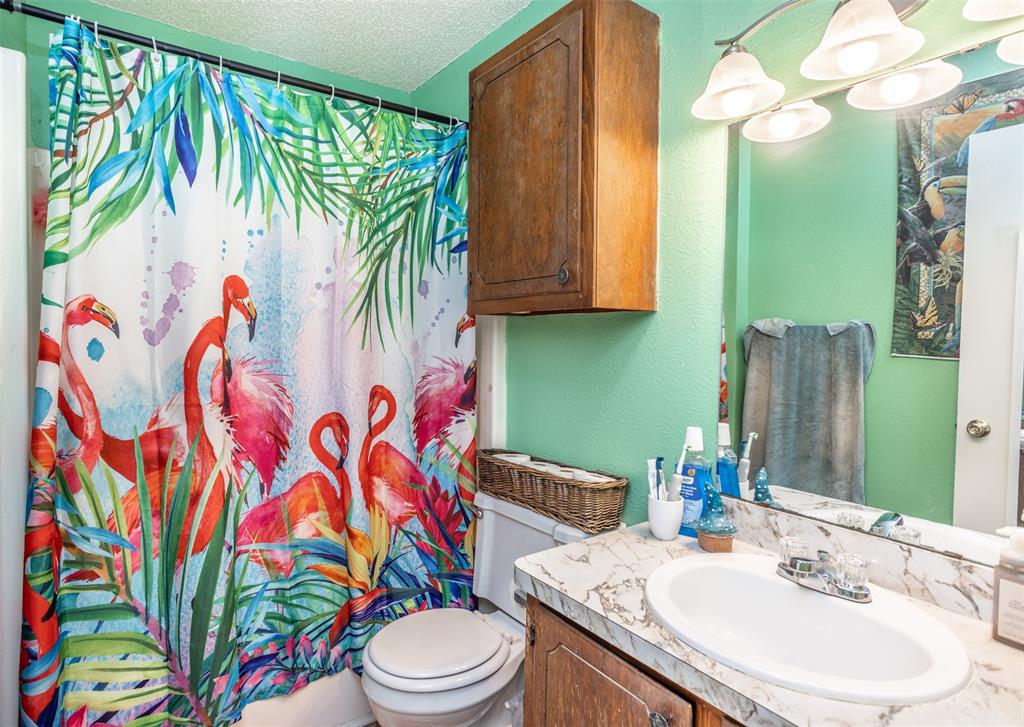 2212 North Aspen Road Gainesville, TX 76240 - Photo 13 of 34 a bathroom with a sink a toilet and a mirror