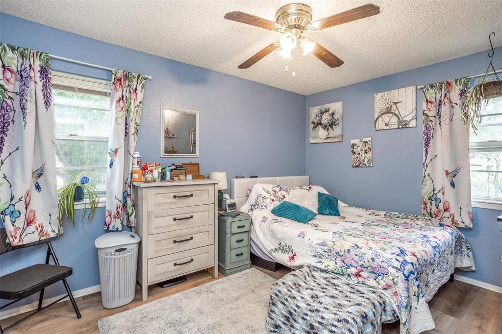 2212 North Aspen Road Gainesville, TX 76240 - Photo 14 of 34 a bedroom with a bed and a chandelier