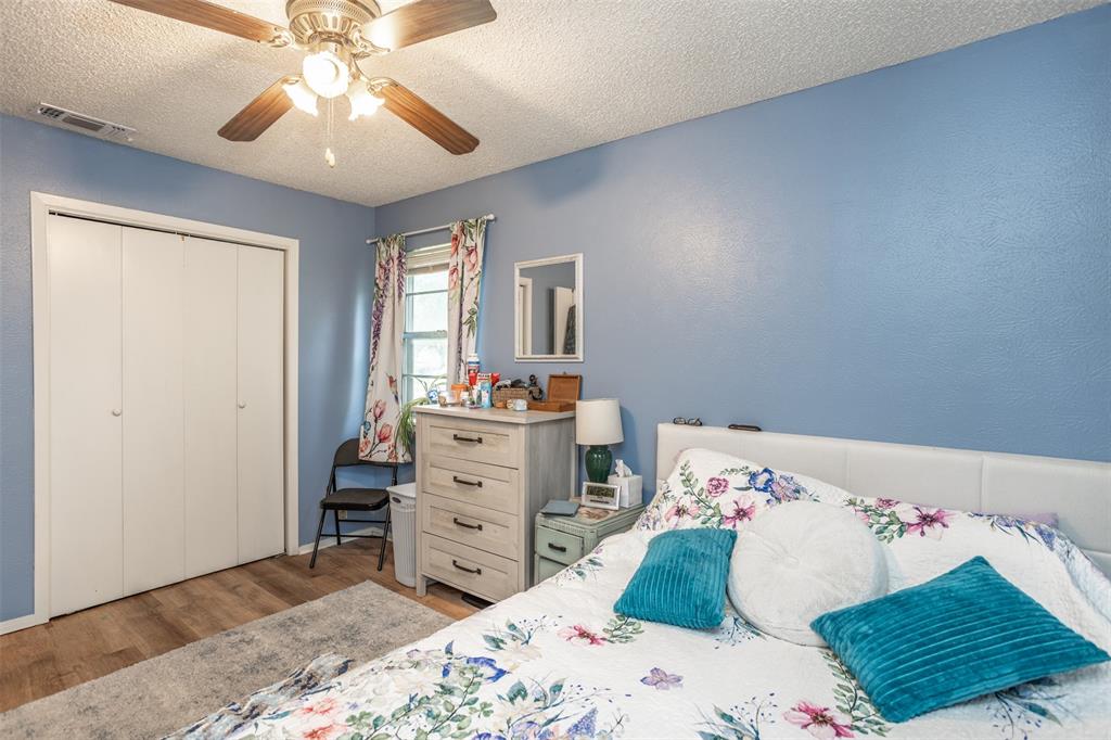 2212 North Aspen Road Gainesville, TX 76240 - Photo 15 of 34 a bedroom with a bed and a chandelier