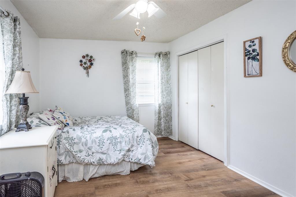 2212 North Aspen Road Gainesville, TX 76240 - Photo 17 of 34 a bedroom with a bed and a chandelier