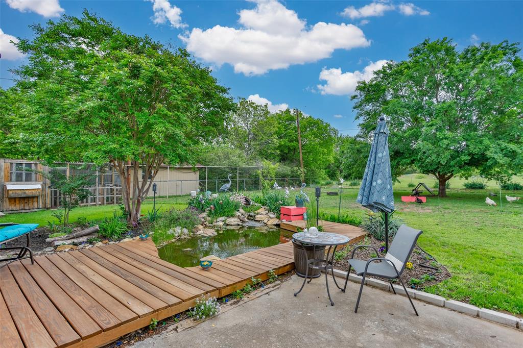 2212 North Aspen Road Gainesville, TX 76240 - Photo 18 of 34 a wooden bench sitting in the middle of a garden