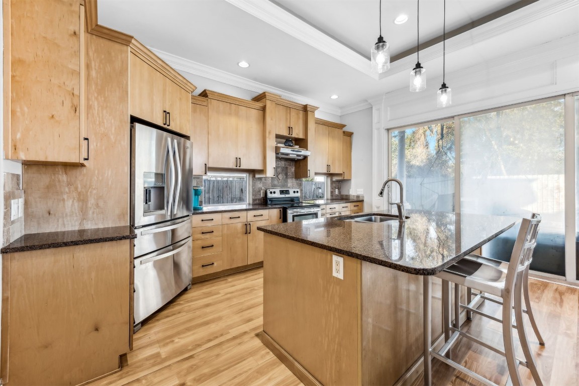 2513 Safe Harbor Lane Fernandina Beach, FL 32034 - Photo 8 of 54 a kitchen with stainless steel appliances granite countertop a sink a stove a refrigerator cabinets and a dining table with wooden floor