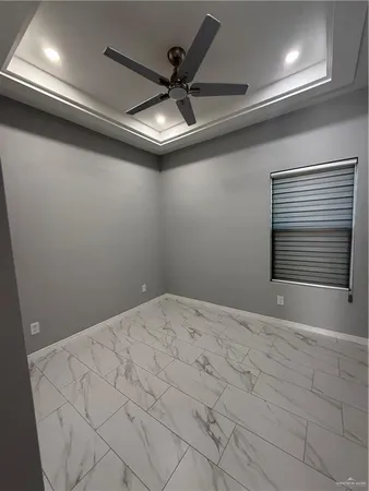 a view of an empty room and a ceiling fan